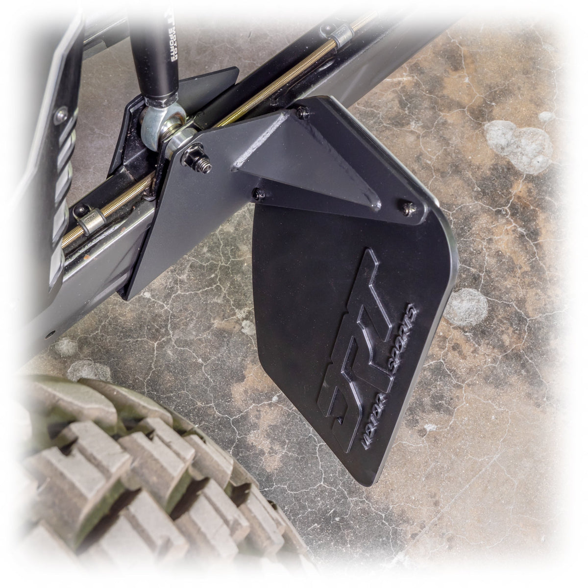 Rock guard protecting CV boots and brake calipers on UTV rear suspension